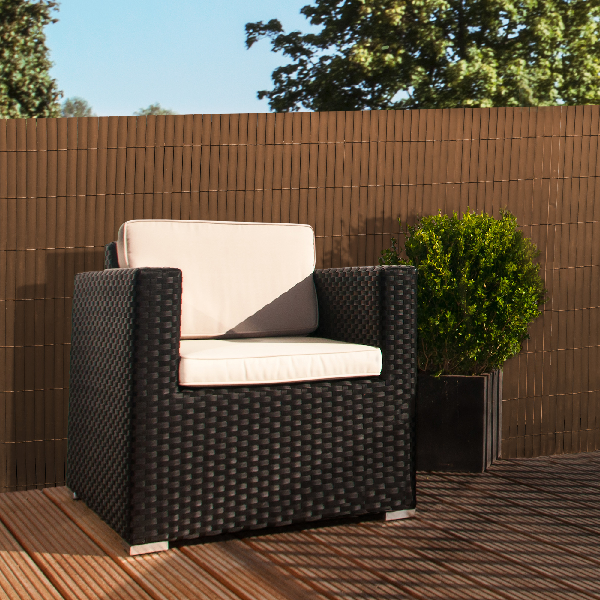 Sichtschutzmatte aus PVC auf Terrasse mit Sessel und Pflanze im Hintergrund