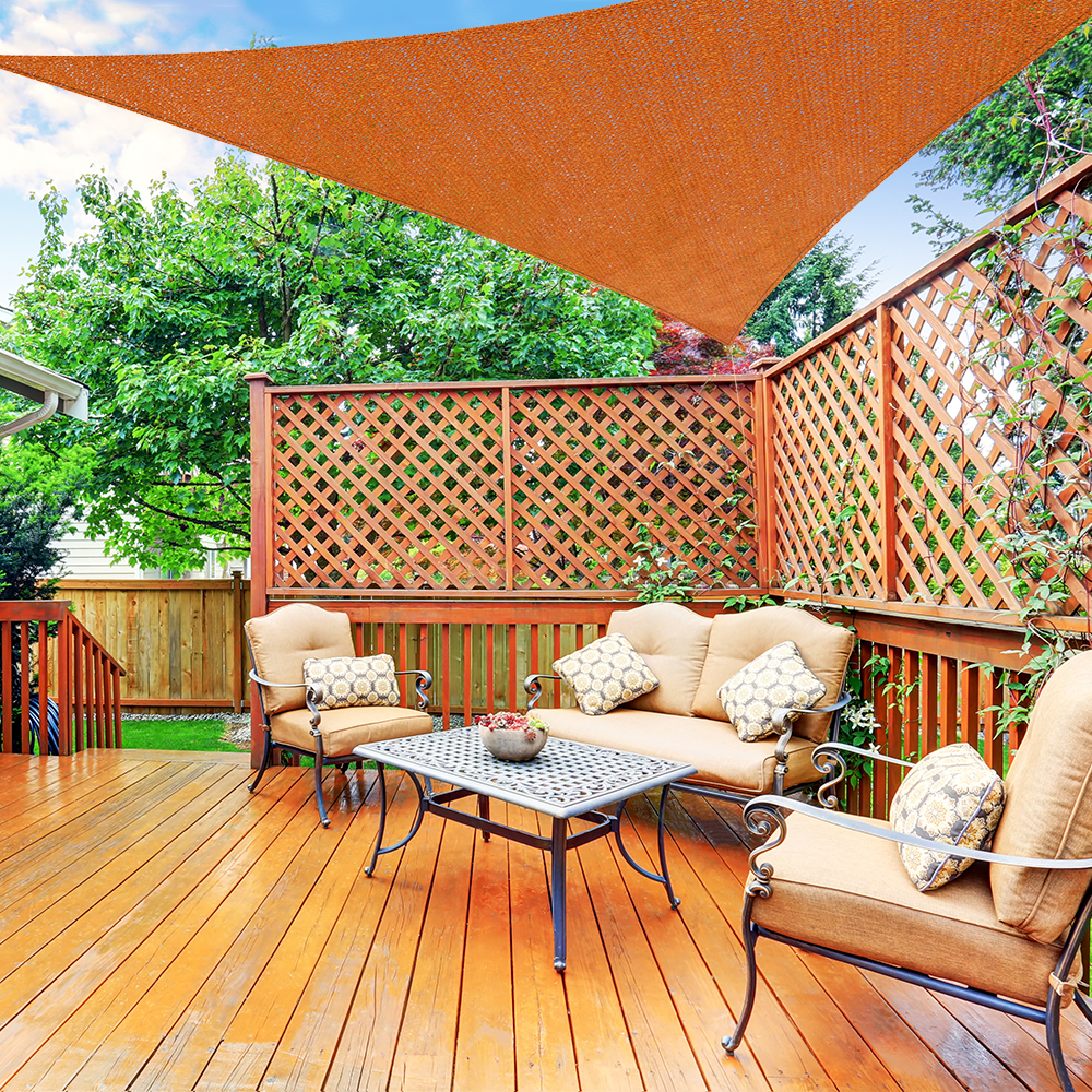Terrasse mit Möbeln und einem dreieckigen, atmungsaktiven Sonnensegel aus HDPE overhead