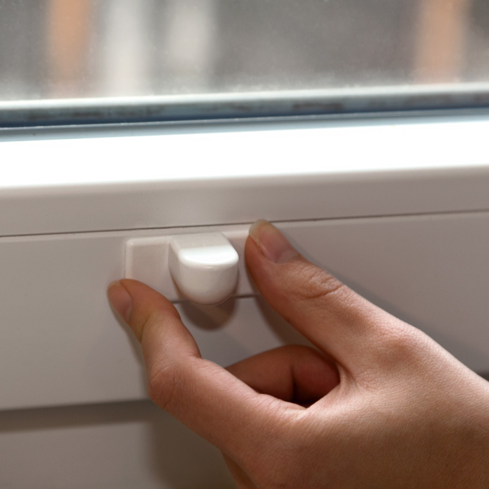 Hand justiert Magnethalter für Jalousie-Unterleiste an einem Fensterrahmen