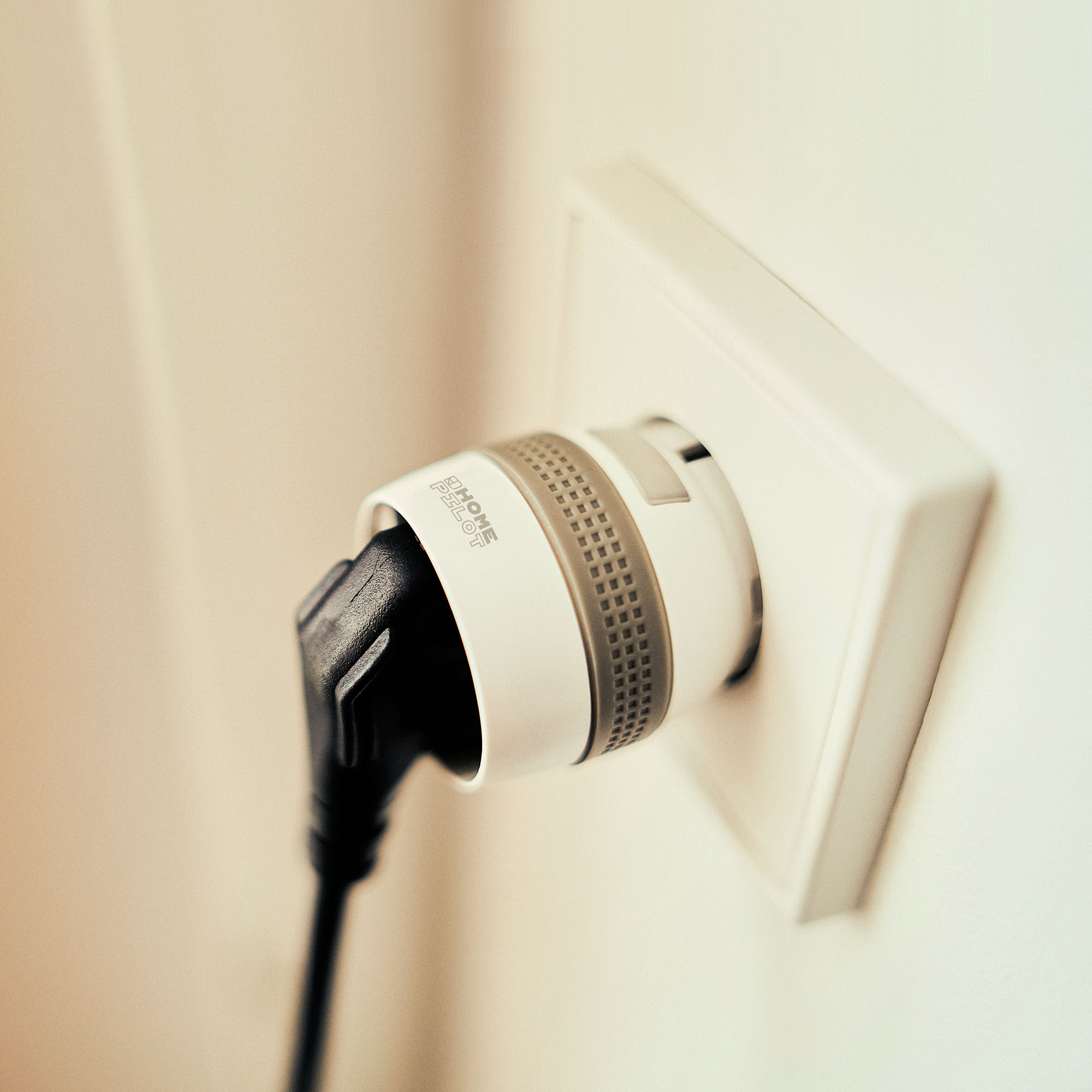 Smart-Zwischenstecker in Steckdose mit eingestecktem Kabel, zeigt smarte Funktionalität