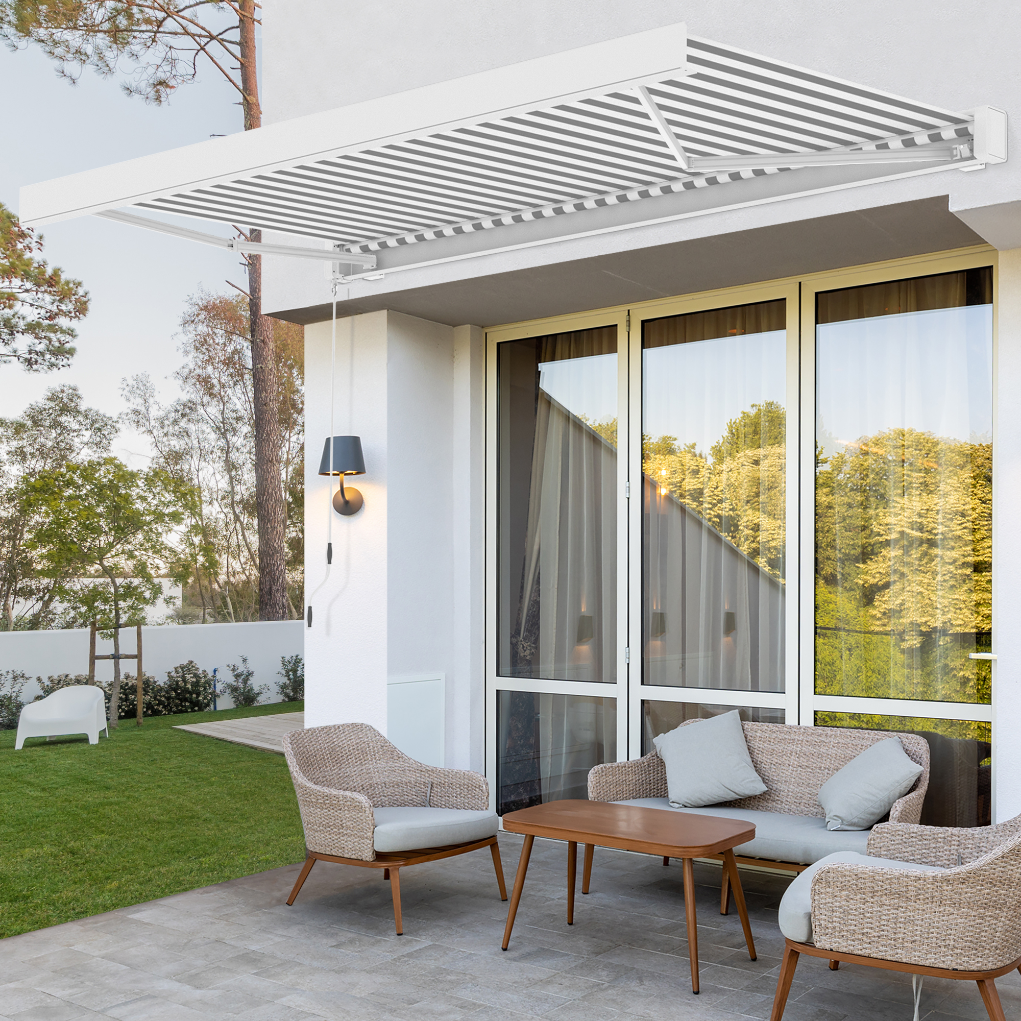 Terrassenmarkise mit LED-Beleuchtung über Sitzgruppe vor Glasfront