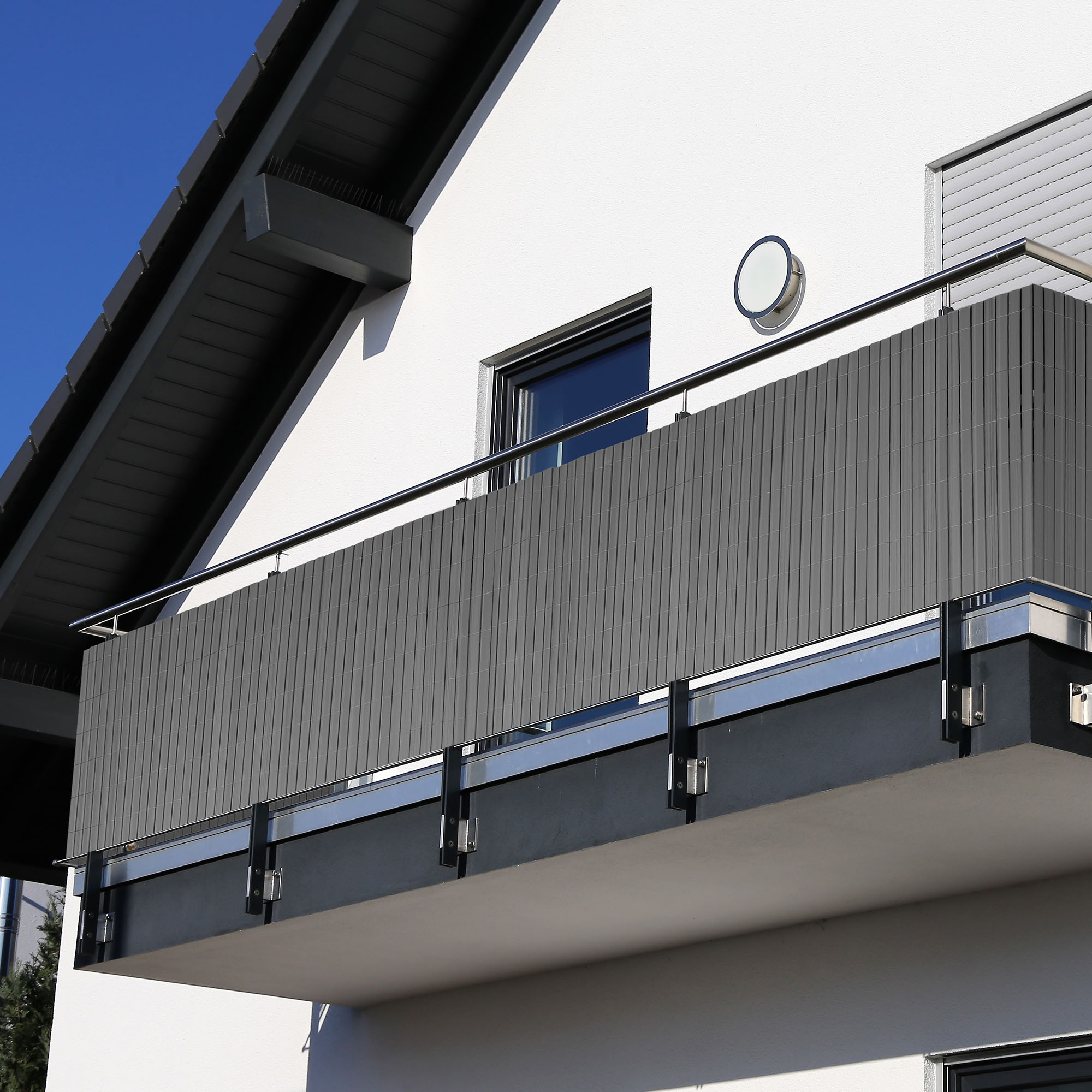 Gedeckter Tisch auf Balkon mit Pflanzen und Sonnenschirm, Frühstücksszene im Freien
