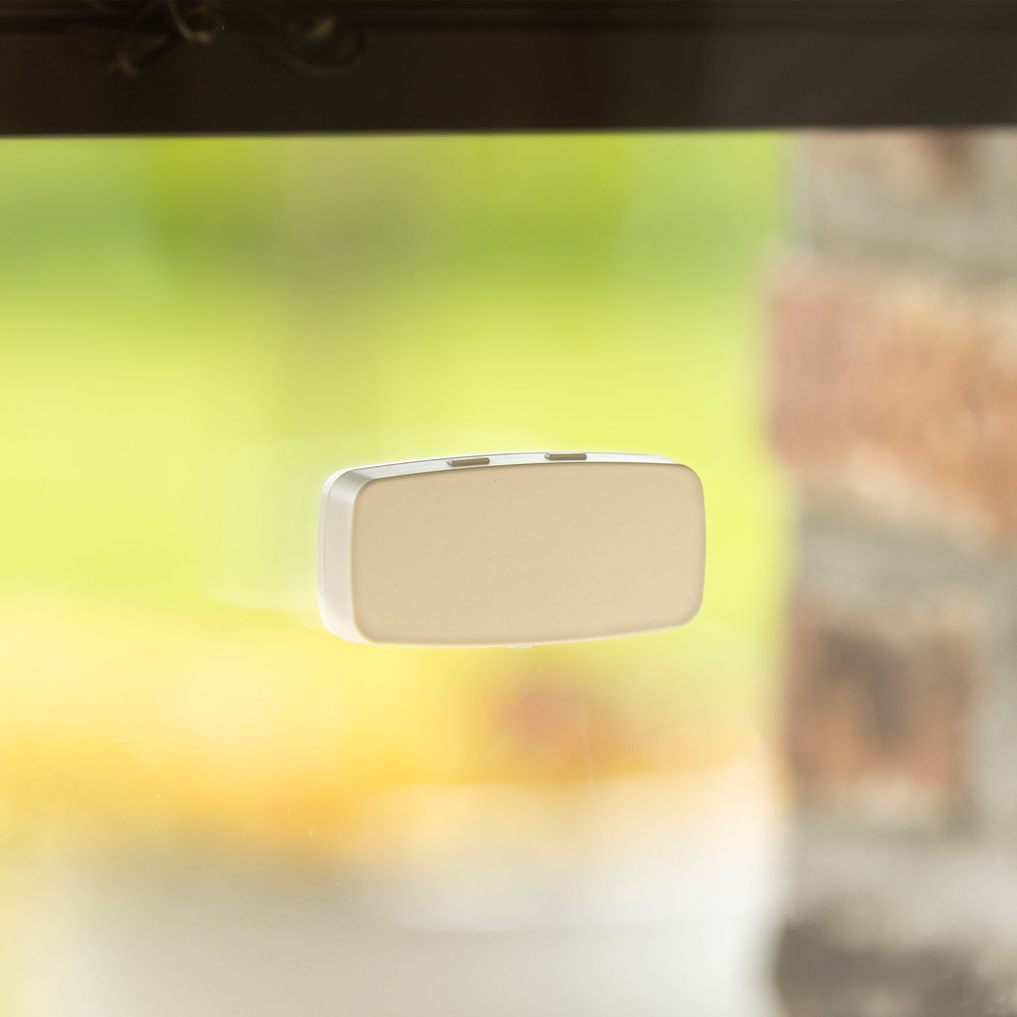 Rechteckiger Sonnensensor an einer Glasscheibe zur Lichtmessung befestigt