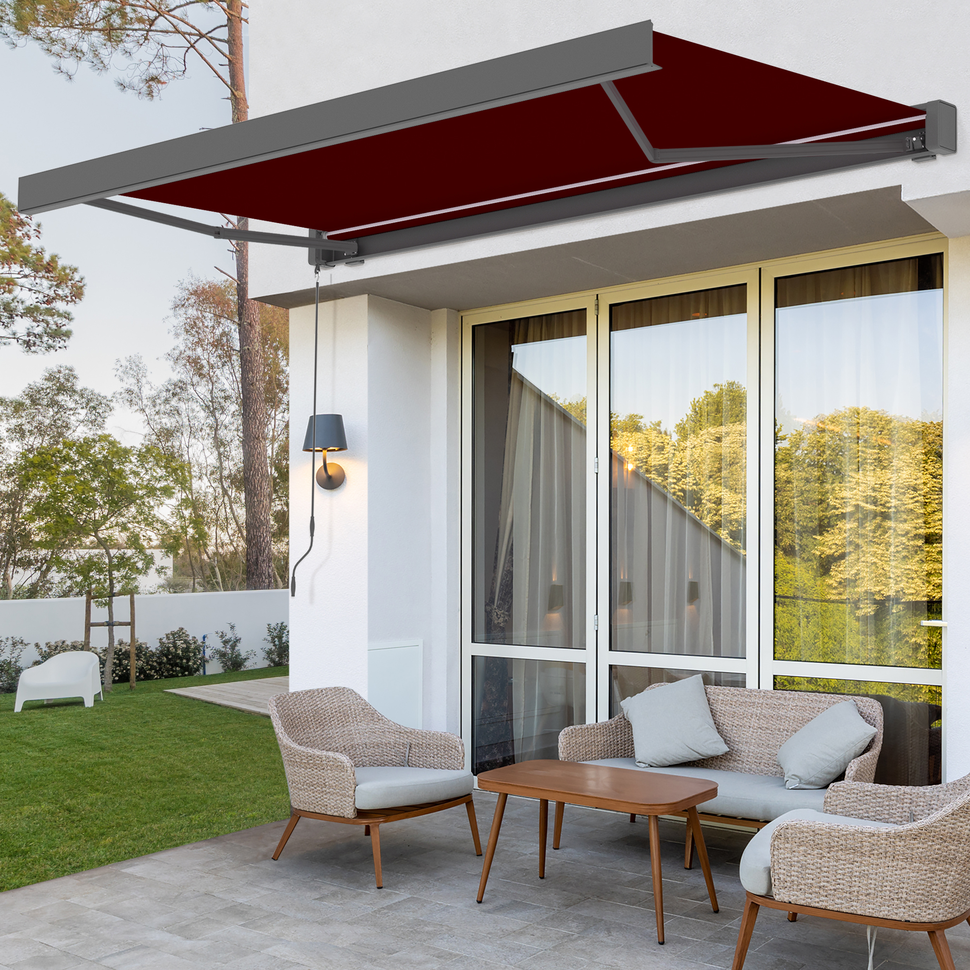 Kassettenmarkise mit LED-Beleuchtung über Terrasse mit Sitzgruppe und Garten im Hintergrund