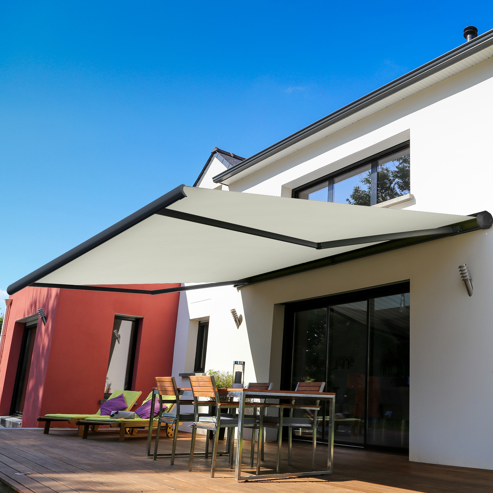 Kassettenmarkise an Hauswand über Terrasse mit Sitzmöbeln und Pflanzen