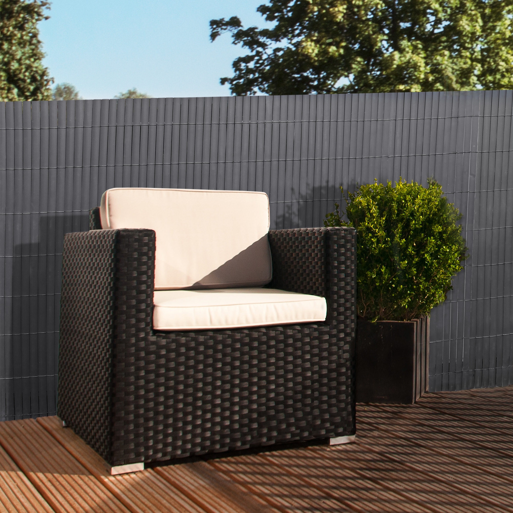 Sichtschutzmatte aus PVC auf Terrasse mit Sessel und Pflanze im Hintergrund