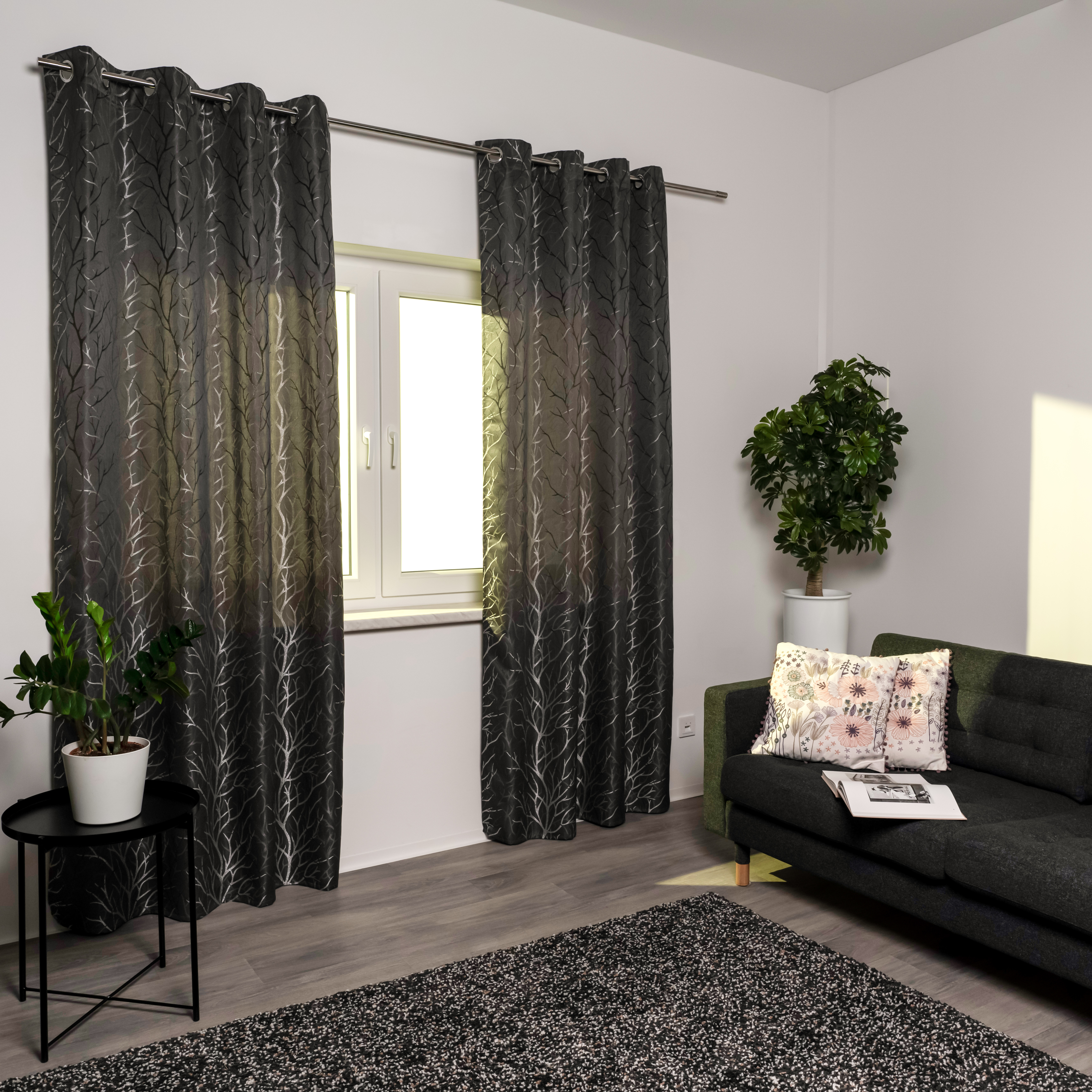 Ösenvorhang vor Fenster in modernem Wohnzimmer mit Sofa und Pflanzen
