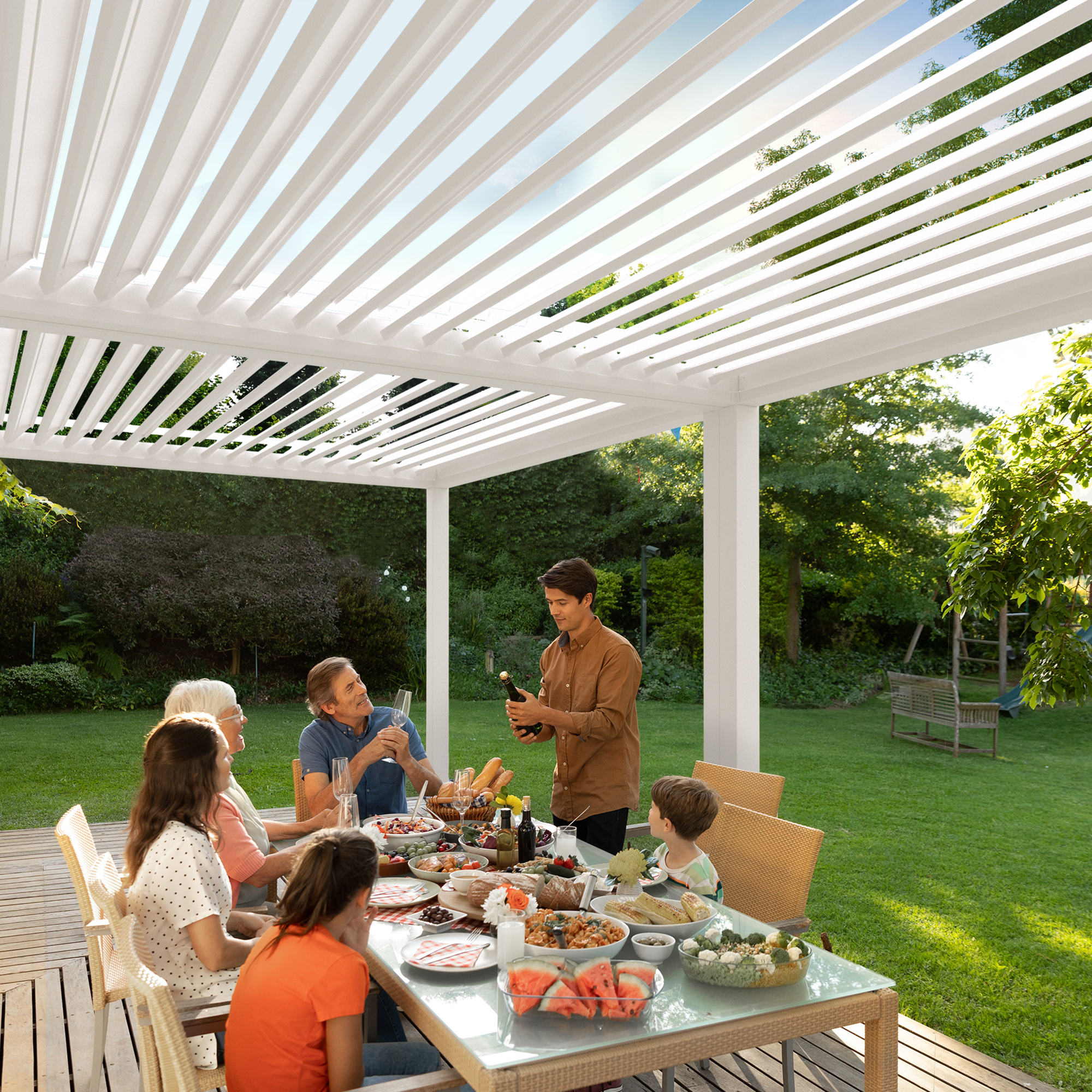 Pergola mit Lamellendach über Esstisch im Garten, Menschen beim Essen und Trinken