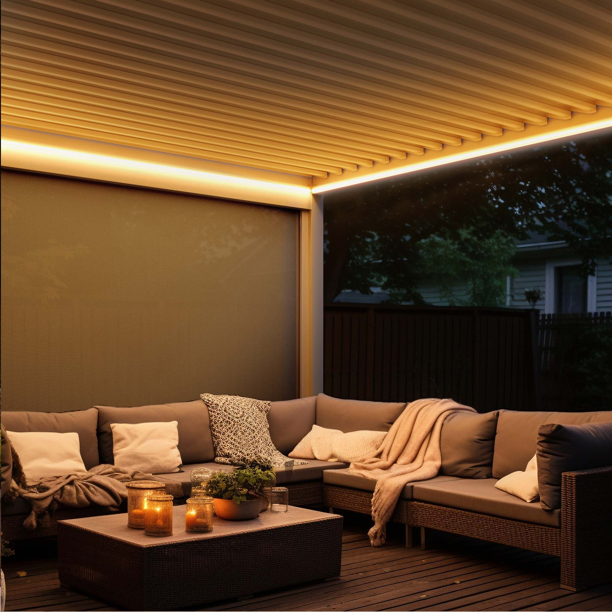 Sitzbereich unter Pergola mit Lamellendach und Sofas, dekoriert mit Kissen und Decken