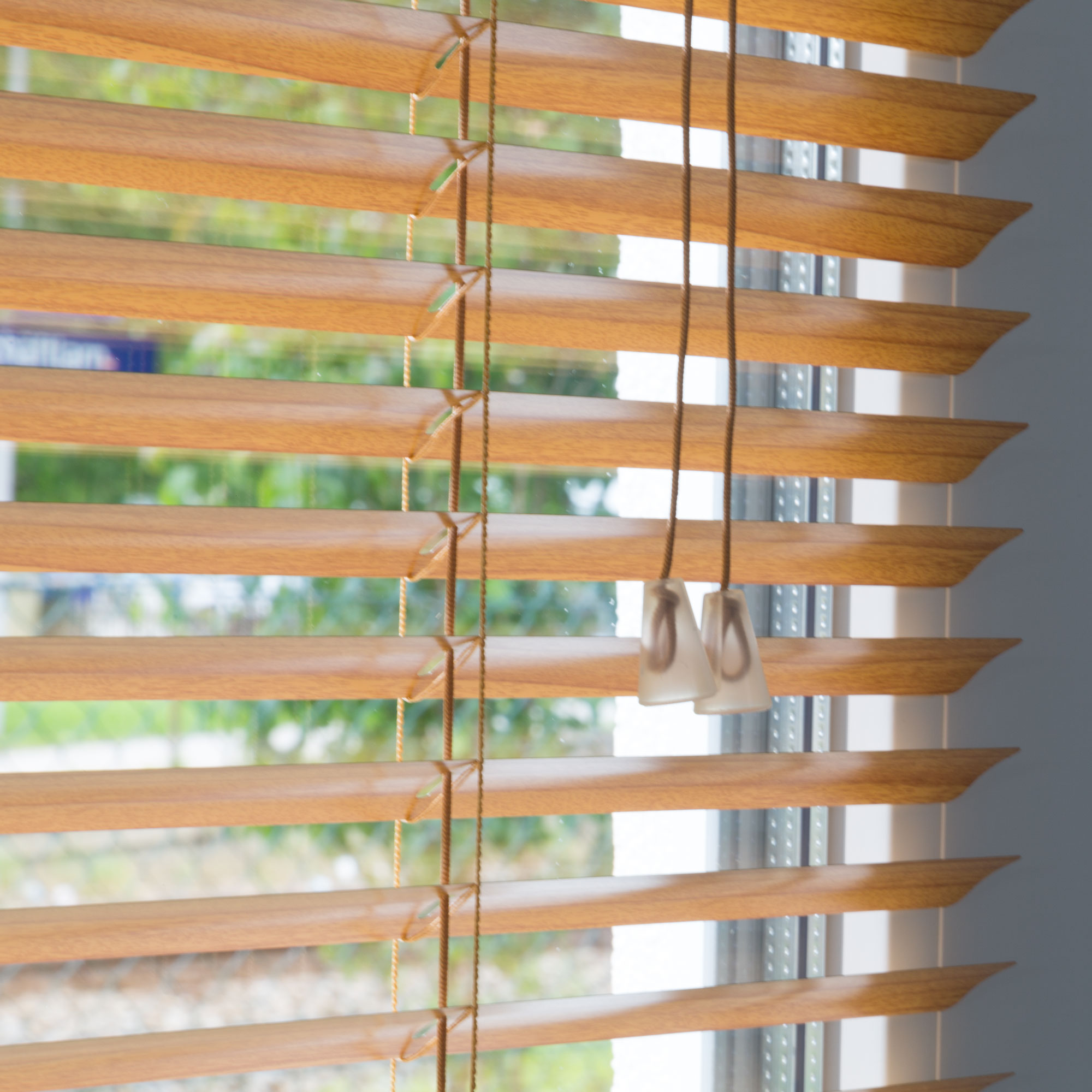 Aluminium Jalousie mit Lamellen und Zugkordel vor einem Fenster