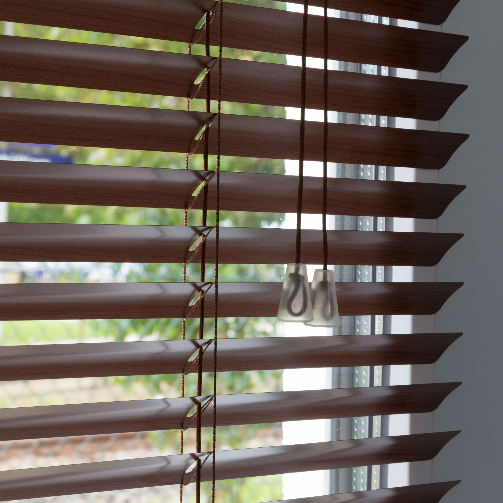 Aluminium Jalousie mit Lamellen und Zugkordel vor einem Fenster